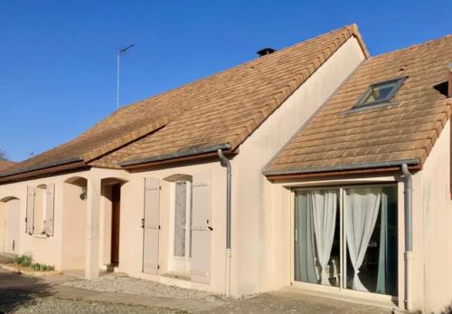 une maison blanche avec un toit marron dans l'établissement Jolie maison à 20 min du circuit des 24h, à Soulitré