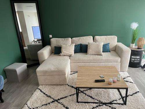 un salon avec un canapé et une table basse dans l'établissement Jolie maison à 20 min du circuit des 24h, à Soulitré