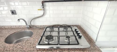 a stove top in a kitchen next to a sink at Zumra's White Houses in Trabzon