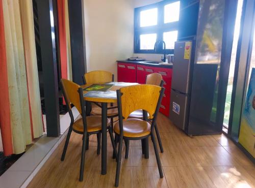 a kitchen with a table and chairs and a refrigerator at Atlantic Bay Resort, Prampram in Prampram