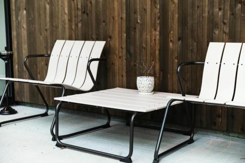 two white chairs and a table with a vase at 山郷 Villas in Nature in Otaru
