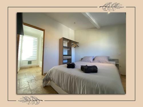 a bedroom with a large bed with two bags on it at Charmant duplex avec tropézienne in Vidauban