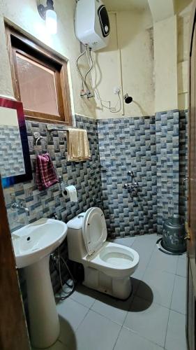 a bathroom with a toilet and a sink at Riwar Homestay in Mawlynnong