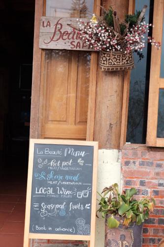 a chalkboard sign in front of a restaurant with a sign at La Beauté Sa Pa in Sa Pa
