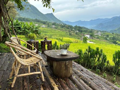 a table and chairs on a wooden table with mountains in the background at La Beauté Sa Pa in Sa Pa