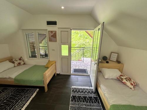 a bedroom with two beds and a door to a balcony at Wolf Apartments near Biogradska Gora in Mojkovac