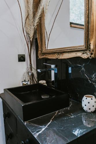 a black sink in a bathroom with a mirror at Appartement Bel Air - Piscine - jacuzzi in Criel-sur-Mer