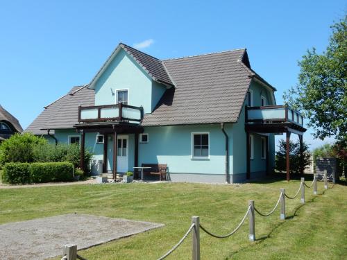 a blue house with a chain in front of it at Haus am Breezter Bodden 1OG in Vieregge