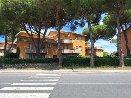 a yellow building with trees on the side of a street at Appartamento le vele in Cecina