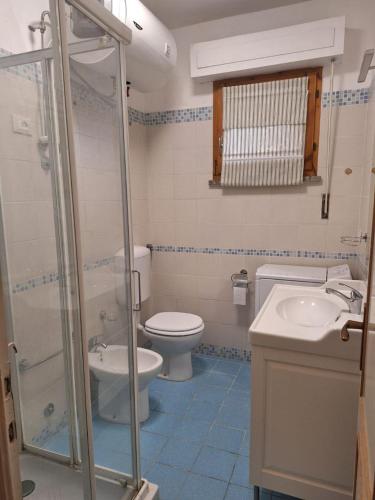 a bathroom with a toilet and a sink and a shower at Appartamento le vele in Cecina