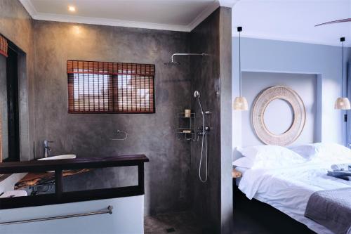 a bathroom with a shower and a bed in a room at Villa La Mercy Maisonette -No load shedding or water outage in La Mercy
