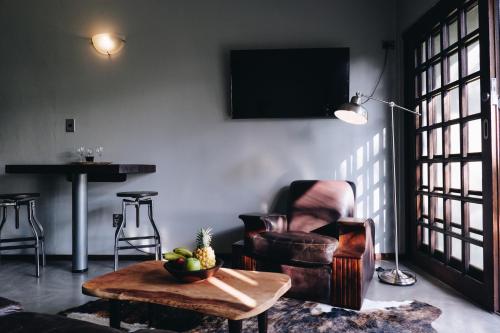a living room with a chair and a table at Villa La Mercy Maisonette -No load shedding or water outage in La Mercy