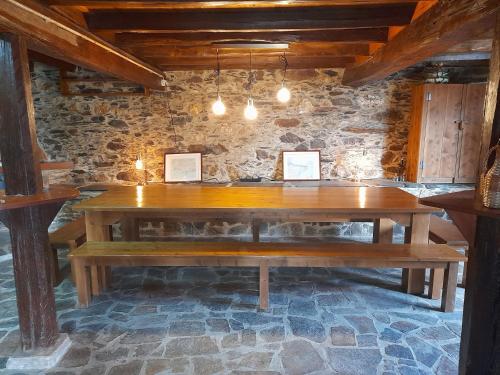 a wooden table in a room with a stone wall at Casa Adega in Vale de Cameiro