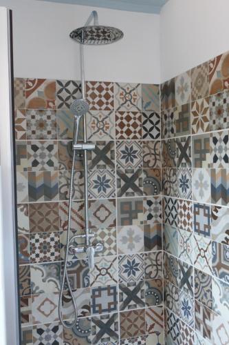 a bathroom with a shower with different tiles on the wall at Casa Adega in Vale de Cameiro