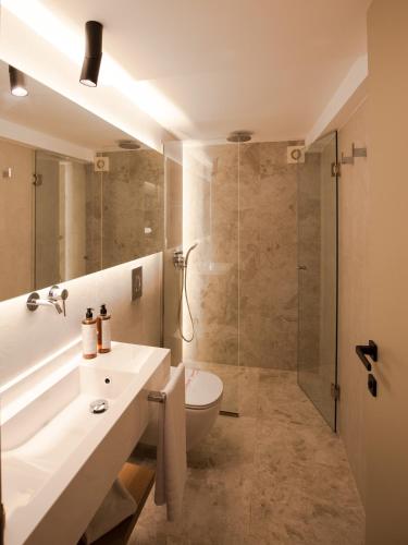 a bathroom with a sink and a toilet and a shower at Akti Hotel Kavala in Paleo Tsifliki