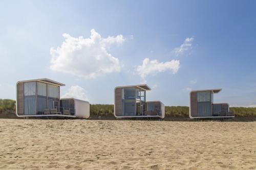 a group of three mobile homes on a beach at Strandhuis, Beachhouse - Slapen op het strand, Sleep at the beach in Nieuwvliet