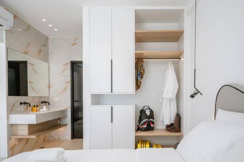 a bedroom with a bed and a sink in a room at Sardines Luxury Suites in Hersonissos