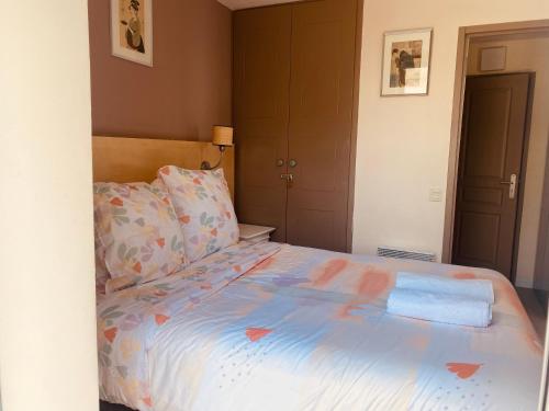 a bedroom with a bed with a blue comforter at Sunny Home Costa Plana-Monaco -Cap D'Ail in Cap d'Ail