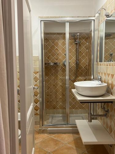 uma casa de banho com um lavatório e uma cabina de duche em vidro. em Appartamento il Paguro a Cala Francese em La Maddalena