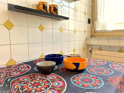 une cuisine avec des bols et des assiettes colorés sur une table dans l'établissement Chez Carnot Centre d'Adamville, à Saint-Maur-des-Fossés