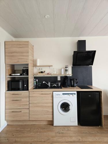 une cuisine avec une machine à laver dans une cuisine dans l'établissement JURA Magnifique Studio Vacances 3 étoiles, à Lamoura