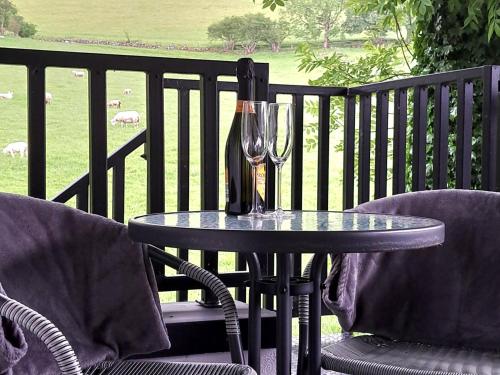 a table with a wine glass on a balcony at Ballymakeever Appartment - Private Hot Tub in Derry Londonderry