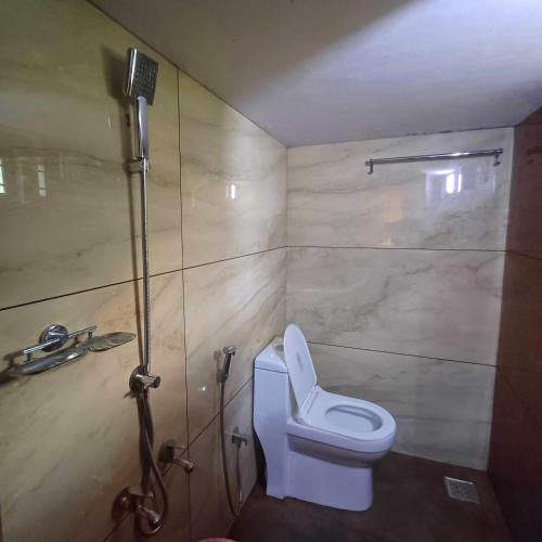 a bathroom with a toilet and a shower at Wayanad Empire Budget Villa in Kalpetta