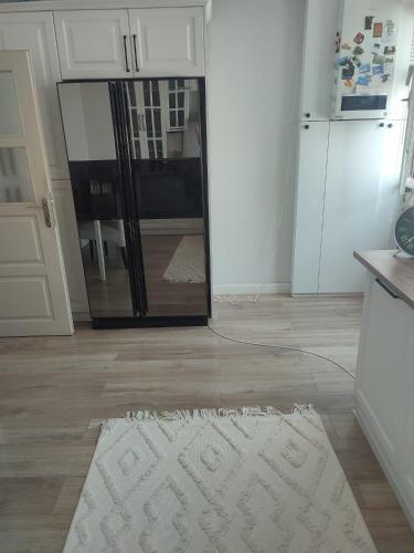 a white rug on a kitchen floor with a refrigerator at Zumra's White Houses in Trabzon