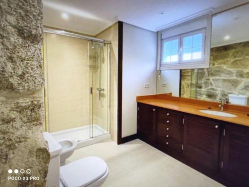 a bathroom with a toilet and a sink and a shower at Villa Cristina in Nigrán