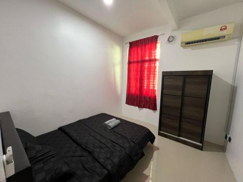 a bedroom with a black bed and a window at Homestay Pool Sg Soi in Kuantan