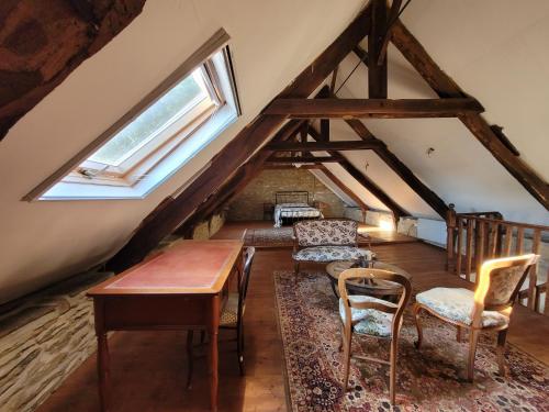 un loft avec une table, des chaises et une fenêtre dans l'établissement Les Gites Audrain, à Plussulien