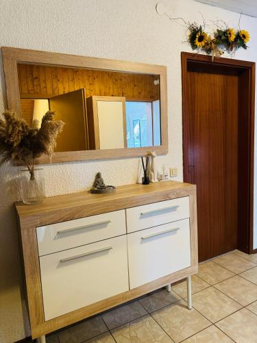 a dresser in a room with a mirror at 3 Zimmer modern Wohnung mit Netflix und küche in Celle
