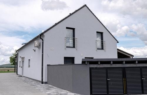 a white house with a garage at apartmány Miška Mirkovice in Mirkovice