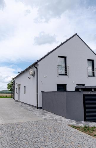 a white building with a garage and a driveway at apartmány Miška Mirkovice in Mirkovice