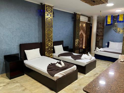 a room with two beds and a table at Comfort Sphinx Inn in Cairo