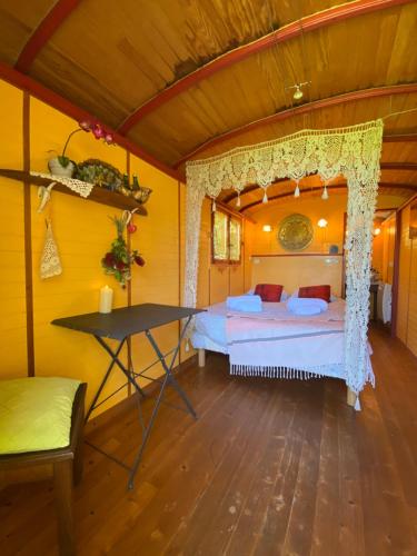 a bedroom with a bed and a table in a room at La Roulotte de Kastell dinn à Morgat in Crozon