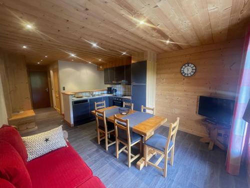 une cuisine et une salle à manger avec une table et des chaises dans l'établissement Aravis Locations, au Grand-Bornand