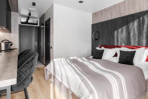 a bedroom with a large white bed and a kitchen at Glacier Premium Apartments in Bukovel