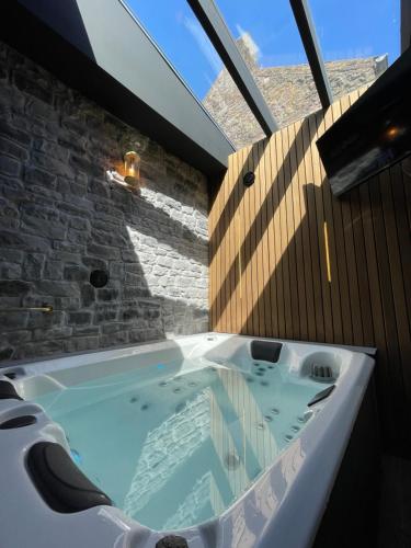a bath tub in a room with a window at La Suite Spa privatif Le Revella in Profondeville