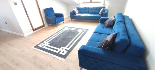 a blue couch and two chairs in a living room at Zumra's White Houses in Trabzon