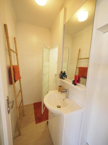 une salle de bain blanche avec un lavabo et un miroir dans l'établissement A l'Orée des Sables, à La Rudelière