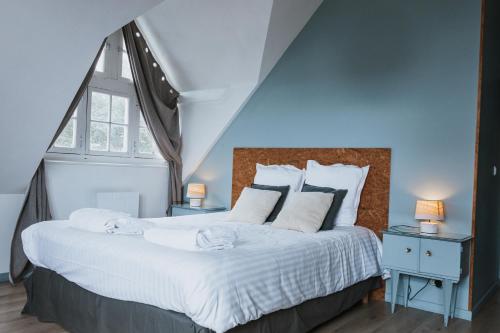 a bedroom with a large bed with white sheets and pillows at La Villa in Mesnil-Val-Plage