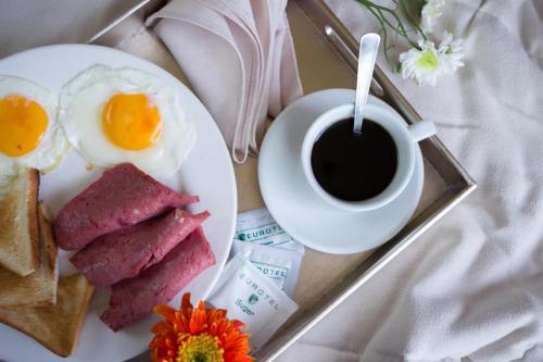 a plate of food with eggs and toast and a cup of coffee at Eurotel Pedro Gil in Manila