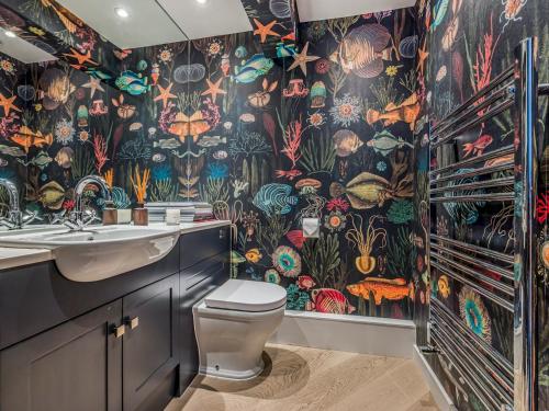 een badkamer met toilet en kleurrijk behang bij Modern Stylish Bosham Home - Pass The Keys in Bosham