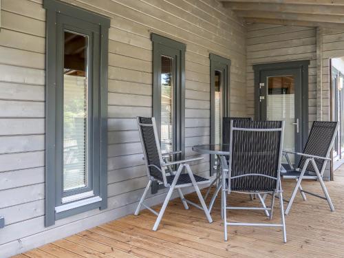 a patio with chairs and a table on a porch at Holiday Home Ferienhaus Barbara by Interhome in Enspel