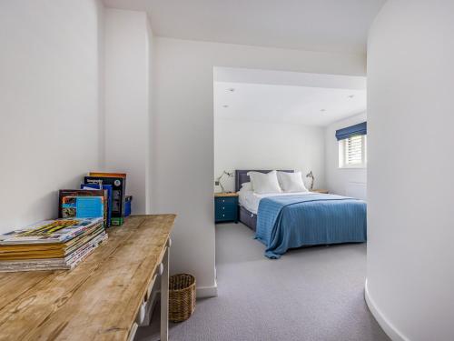 een slaapkamer met een bed en een tafel met boeken bij Modern Stylish Bosham Home - Pass The Keys in Bosham
