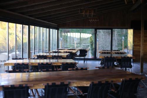 a group of tables and chairs in a room with windows at Pagen Bungalow in Hopa