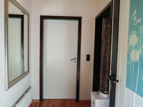 a hallway with a white door and a mirror at Holiday Home Scout by Interhome in Machtlos
