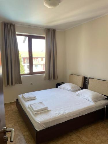 a bedroom with two beds and a window at private apartments in Apolon in Ravda