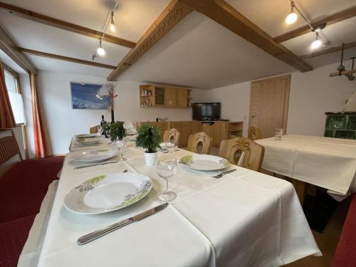 a table with plates and wine glasses on it at Holiday Home Zentral by Interhome in Schnann